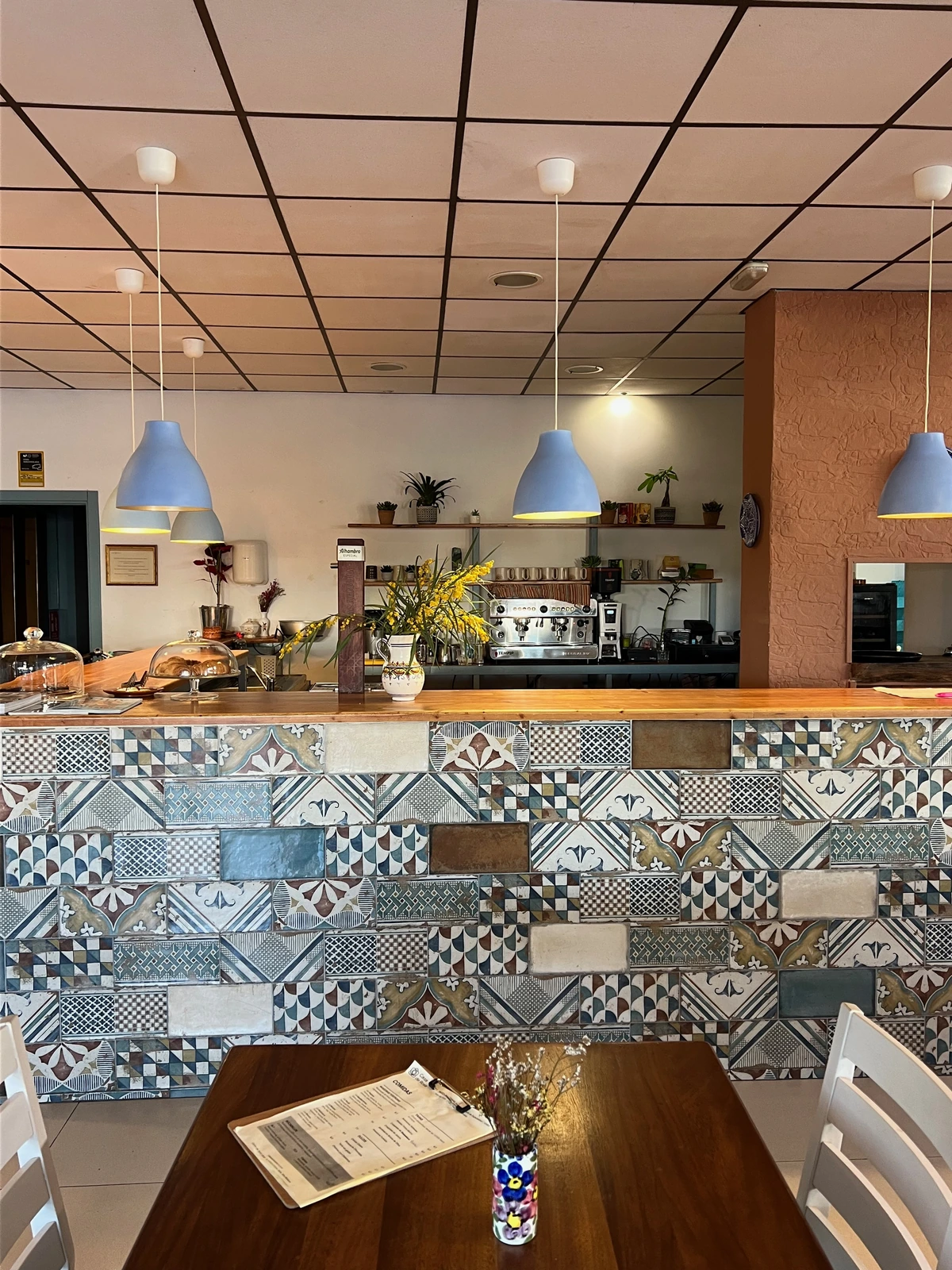 Vista amplia desde una mesa hacia la barra estampada y la iluminación
