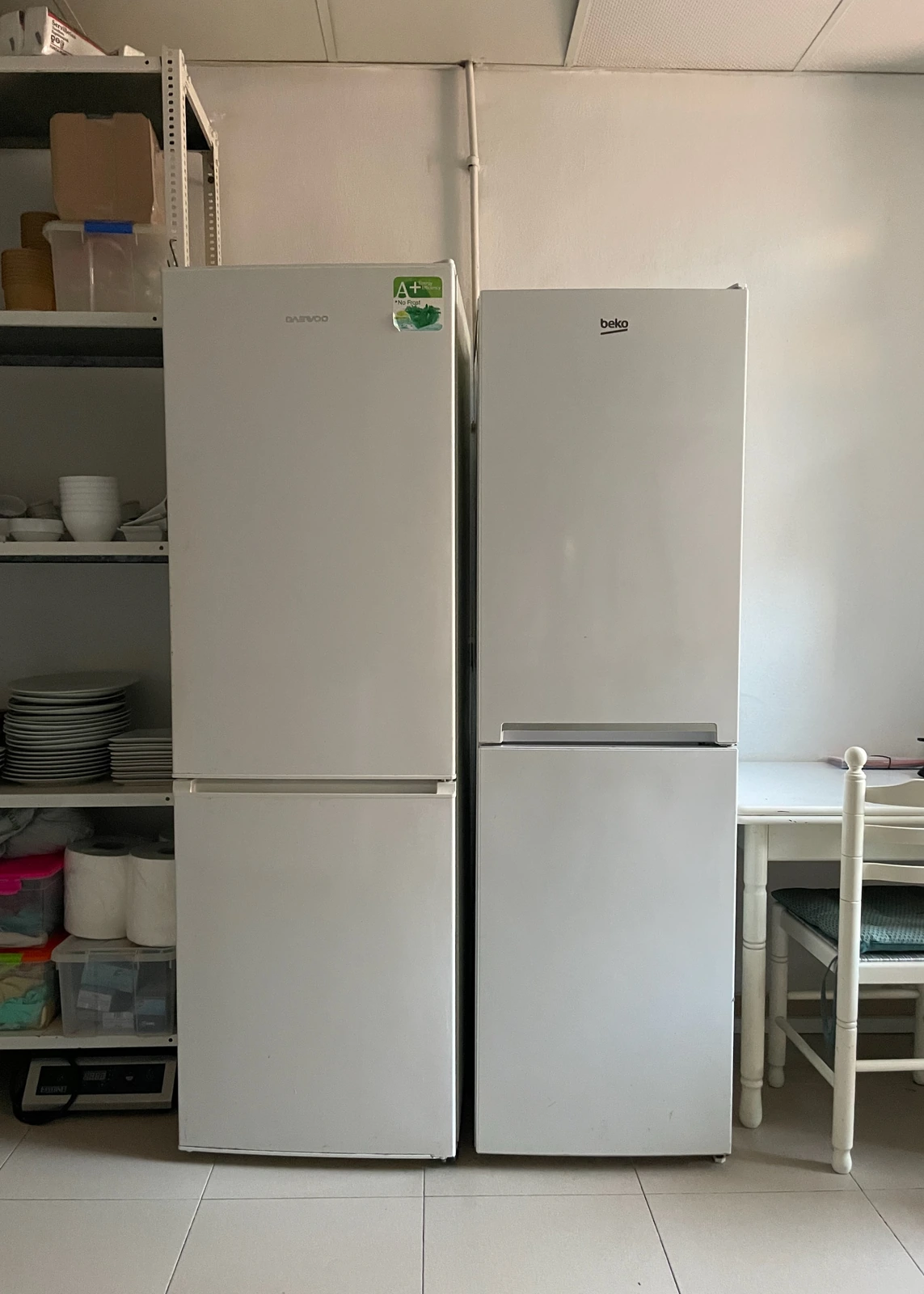 Dos frigoríficos verticales en zona de almacén con estantería