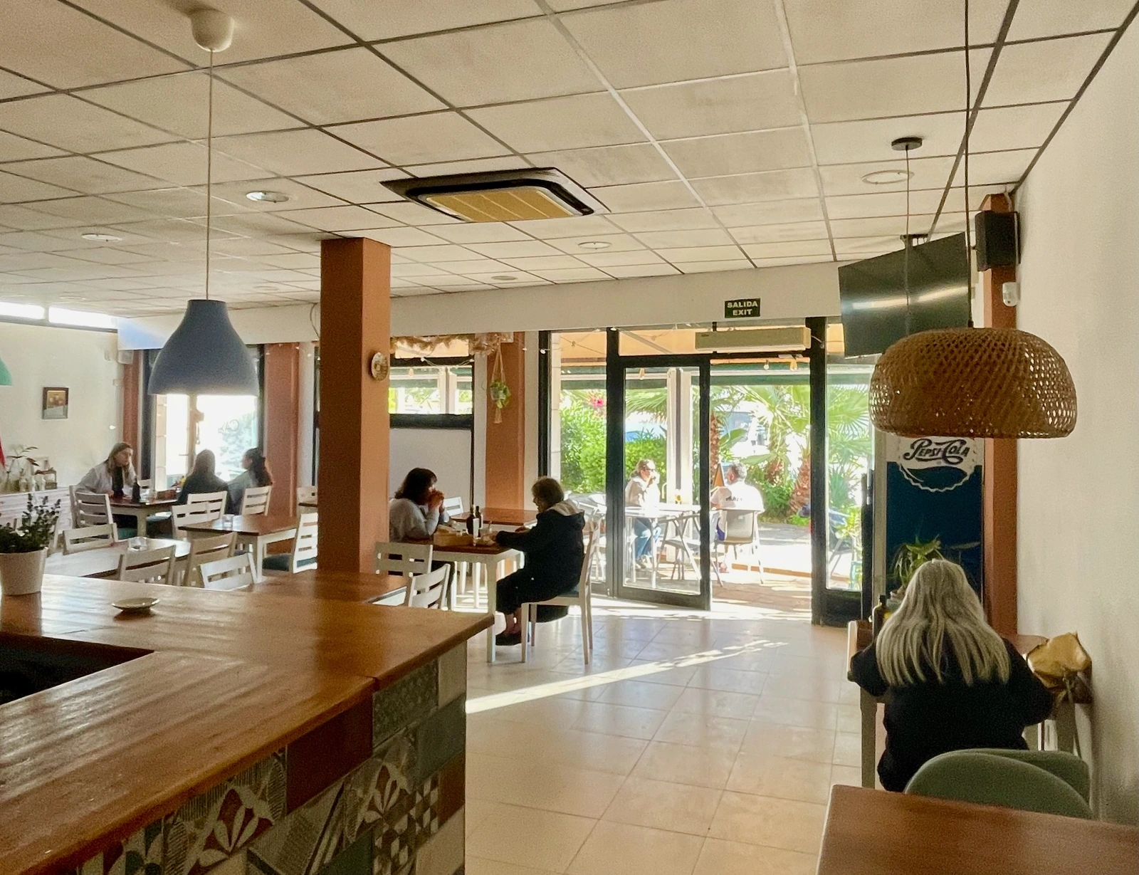 Vista amplia desde la barra hacia la sala con clientes